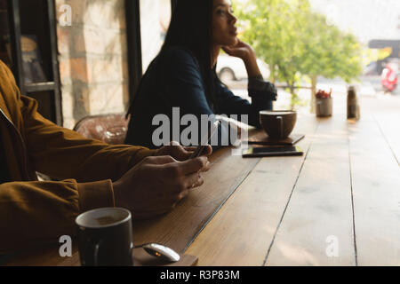 Man using mobile phone in cafe Stock Photo
