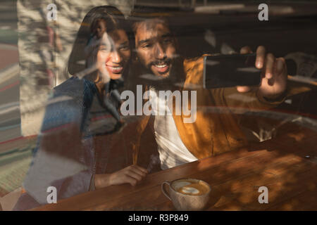 Couple taking selfie in cafe Stock Photo