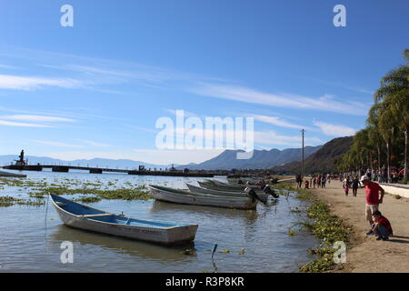 foto tomada a la orilla del lago de Chapala-Jalisco-Mexico en donde se aprecian a un padre y su hijo observando el lago desde la playa Stock Photo