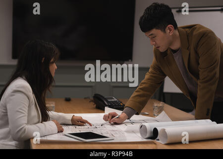 Executives discussing over blueprint Stock Photo