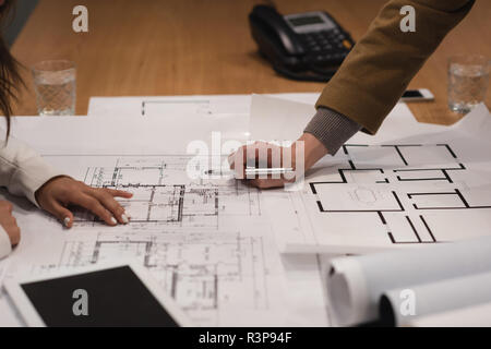 Executives discussing over blueprint Stock Photo