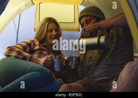 Couple having coffee in tent Stock Photo
