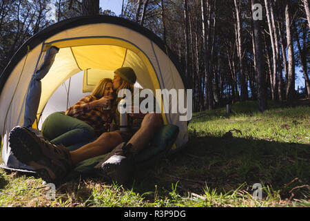 Couple having coffee in tent Stock Photo