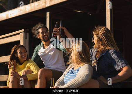 Group of friends toasting beer bottle on cabin Stock Photo