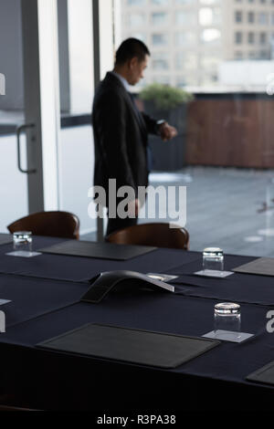 Businessman checking time on his watch in conference room Stock Photo