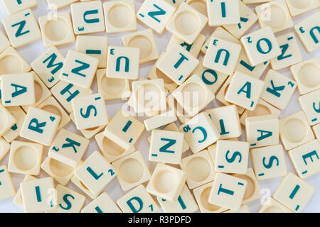 Pile of random Scrabble game letter tiles with score value mixed up background, viewed from above. Stock Photo