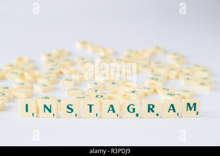 Focus on the word 'Instagram' made of Scrabble game letter tiles with score value, random tiles mixed up in the background. Shallow depth of field. Stock Photo