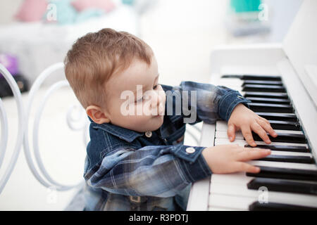 Little boy plays a piano Stock Photo