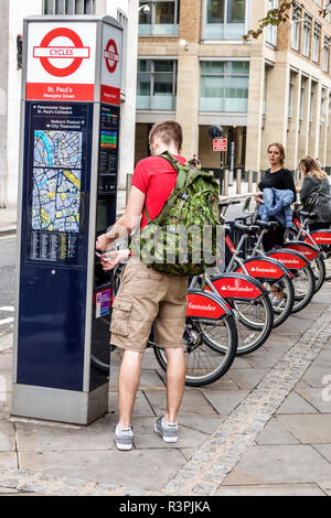 City of London England,UK Santander Cycles,public bicycle hire scheme,bike sharing,Boris Bikes,pay station,man men male,backpack,transaction paying,UK Stock Photo