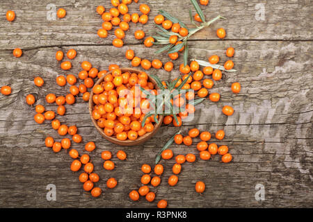 Sea buckthorn. Ripe fresh berries in bowl on old wooden background with copy space for your text. Top view Stock Photo