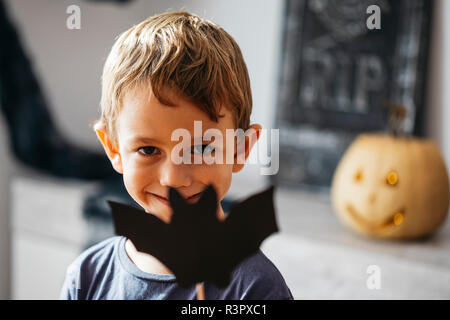Portrait of smiling little boy with cardboard bat Stock Photo