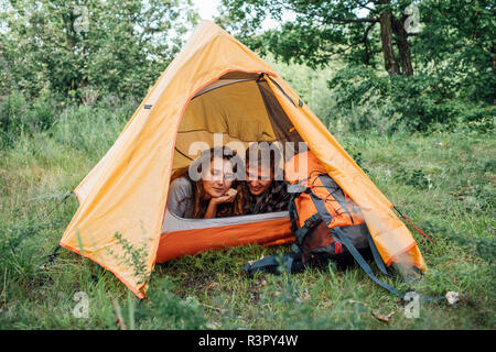 Young couple camping in nature, lying in tent, taking a break Stock Photo