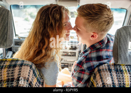 Romantic couple doing road trip, kissing in car