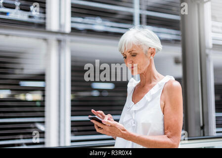 Senior woman using cell phone outdoors Stock Photo