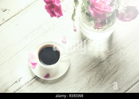 Pink roses and coffe on the wooden table Stock Photo