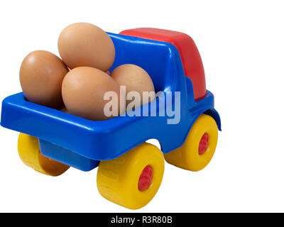 little toy truck full of fresh organic farm yellow eggs. vegetarian farm food market delivery service concept. back closeup shot cutout isolated on wh Stock Photo