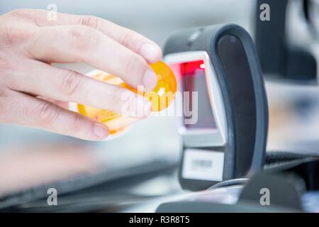 Pharmacist scanning medicine with barcode reader in pharmacy. Stock Photo