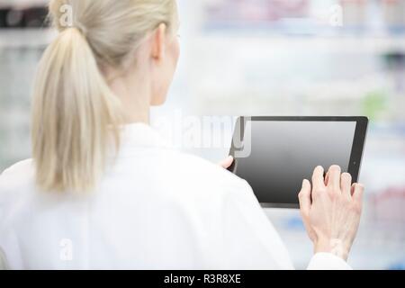 Female pharmacist using digital tablet in pharmacy. Stock Photo