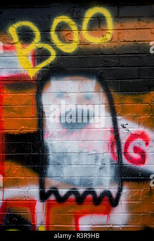 A ghost and the word 'Boo' spray painted on the side of a brick wall - graffiti Stock Photo