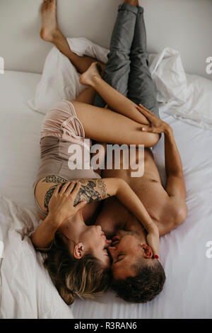 Romantic young couple lying in bed Stock Photo