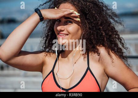 Portrait of smiling young athletic woman wearing bra outdoors Stock Photo