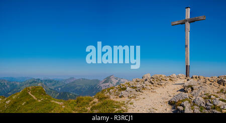 Austria, Walser Hammerspitze summit cross looking over the Allgaeu Alps in Bavaria, Germany Stock Photo