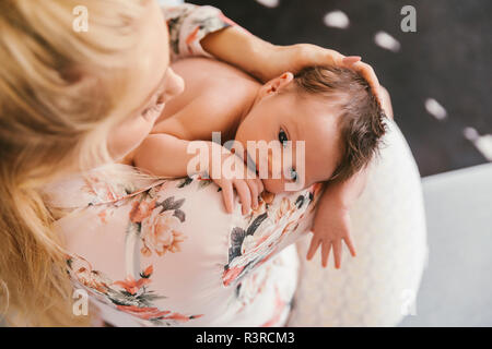 Mother holding her baby close to her shoulder Stock Photo