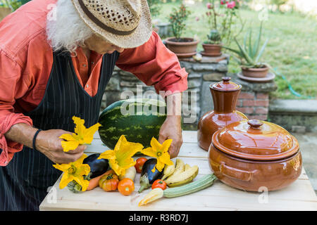 Senior man decorating a table with fruits and vegetables Stock Photo