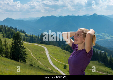 Germany, Bavaria, Brauneck near Lenggries, happy young woman in alpine landscape