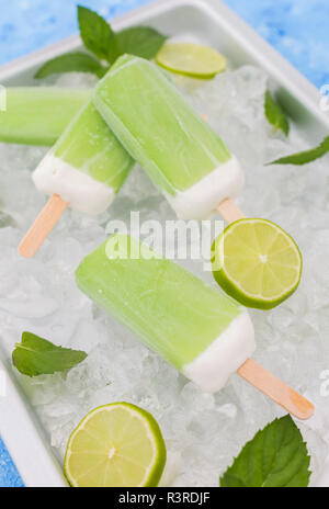 Lime mint popsicles, slices of limes and mint leaves on crushed ice Stock Photo