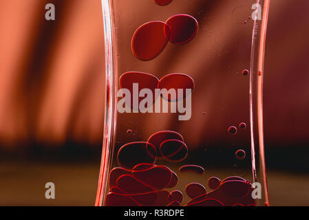 Red drops similar to blood falling in water. Stock Photo