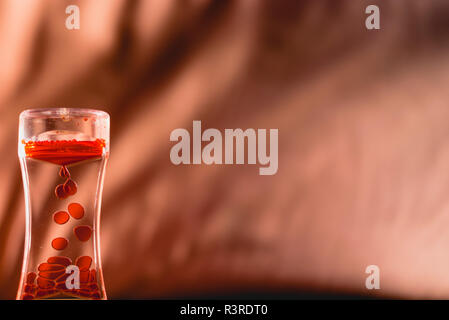 Red drops similar to blood falling in water. Stock Photo
