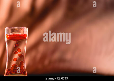 Red drops similar to blood falling in water. Stock Photo