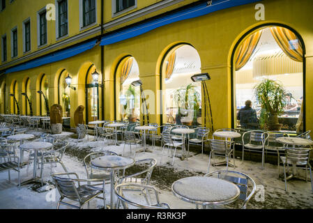 Germany, Bavaria, Munich. Funf Hofe luxury shopping center, outdoor cafe under snow Stock Photo