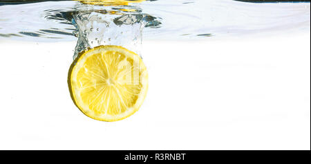 lemon slice is falling into the water, isolated on a white background, copy space Stock Photo