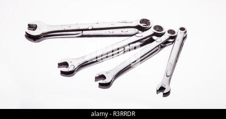 Wrenches of different sizes on a light background in a stream of water. Stock Photo