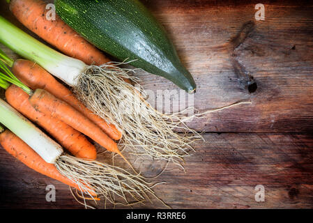 carrots and leek freshly harvested from the vegetable garden on a dark wooden table with copy space, view from above, selected focus, narrow depth of  Stock Photo