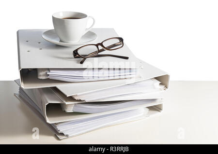 stack of folders, glasses and a cup of coffee on a desk, isolated on a white background, business and finance concept, copy space, selected focus Stock Photo