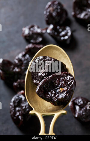 Prunes on a vintage brass spoon Stock Photo