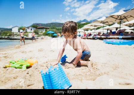 Toddler boy playing on the beach Stock Photo