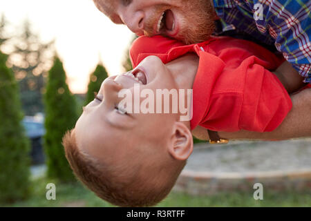 Happy playful father with his son in garden Stock Photo