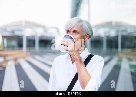Senior businesswoman in the city drinking coffee Stock Photo