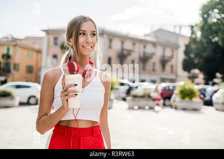 Portrait of smiling teenage girl with takeaway drink in the city Stock Photo