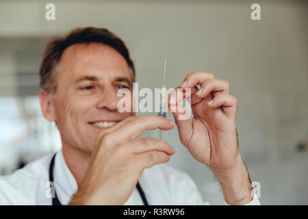 Doctor preparing injection, filling syringe Stock Photo