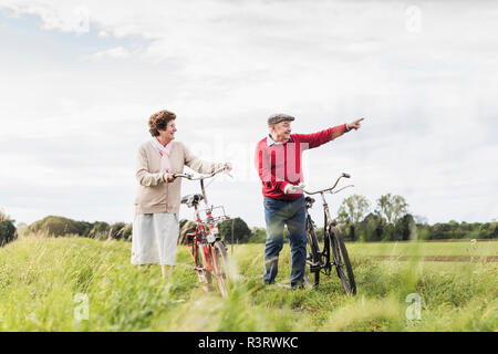 Senior couple with bicycles in rural landscape Stock Photo