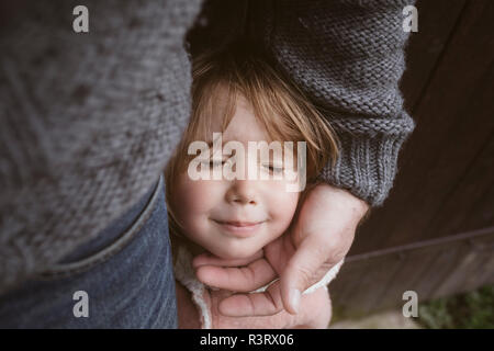 Portrait of blond little girl with eyes closed standing beside her father Stock Photo