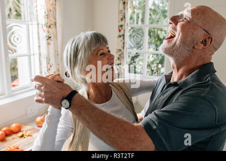 Senior man and woman dancing in joy at home. Happy senior couple having fun doing a ballroom dance at home. Stock Photo