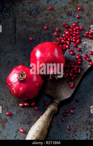 Two whole pomegranates, pomegranate seed and cleaver Stock Photo