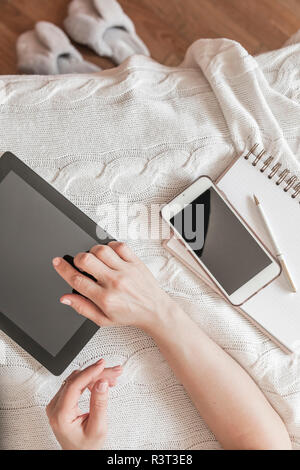 Woman's hand using digital tablet at home, top view Stock Photo
