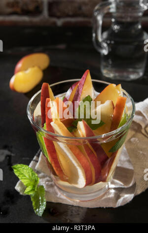 Glass of detox water with sliced red apple and mint Stock Photo